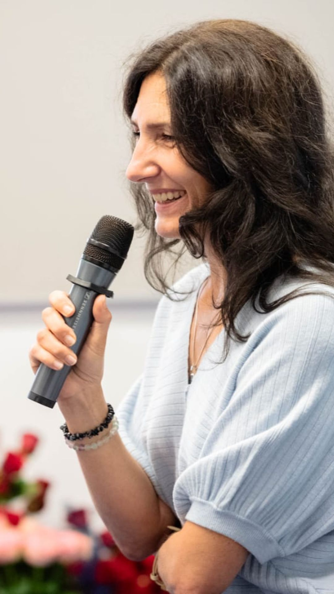 Bogna Gąsiorowska uśmiecha się i przemawia do mikrofonu podczas konferencji.